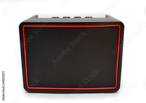 Głośnik bezprzewodowy bluetooth widziany z przodu prostokątny czarny z czerwoną ramką na baterie AA paluszki z pokrętłami u góry photo