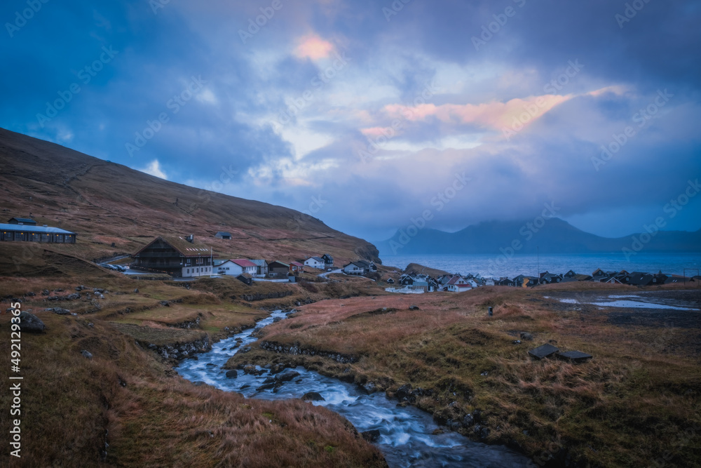 Gjogv village on the island of Eysturoy, Faroe Islands. Scandinavian colored houses. November 2021, sunset time.