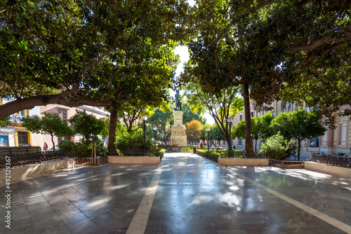 The shaded urban Plaza del Museo a Seville across from the Museum of Fine Arts in Seville, Spain with the monument to Bartolome Esteban Murillo the sculptor.