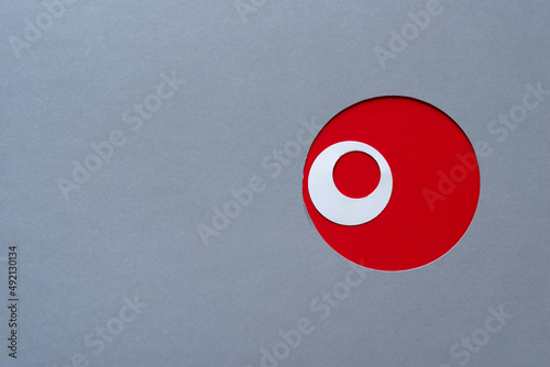 gray paper with red circle hole and white ring