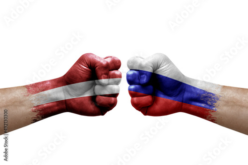 Two hands punch to each others on white background. Country flags painted fists, conflict crisis concept between latvia and russia