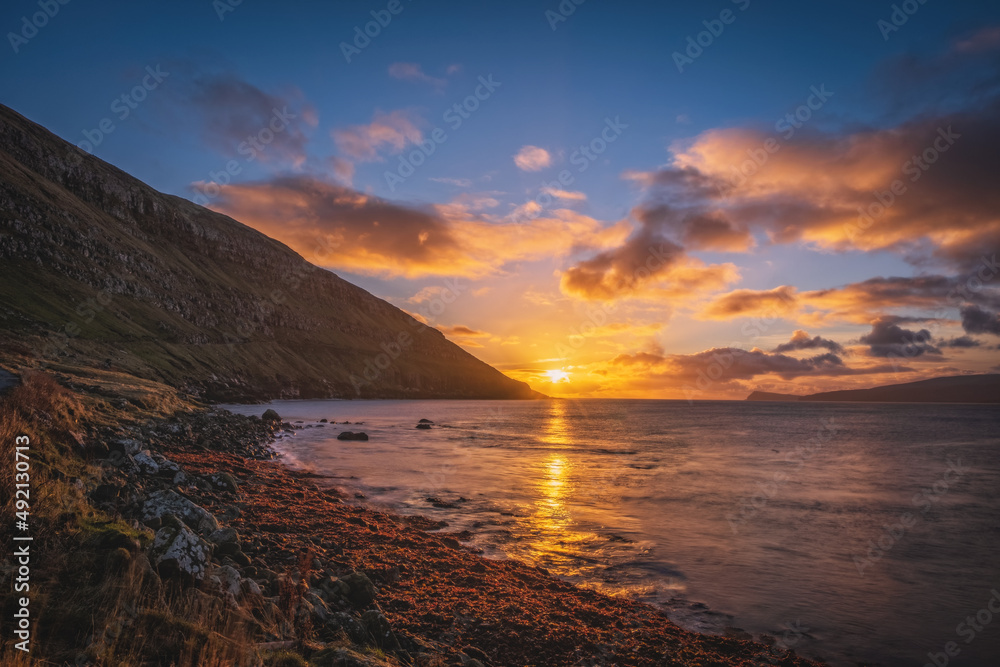 View of Hestur and Koltur Islands across the Hestfjord from the village of Kirkjubour Kirkebo on Streymoy island, Faroe Islands. Sunrise time, november 2021 View of Hestur and Koltur Islands across the Hestfjord from the village of Kirkjubour Kirkebo on Streymoy island, Faroe Islands. Sunrise time, november 2021