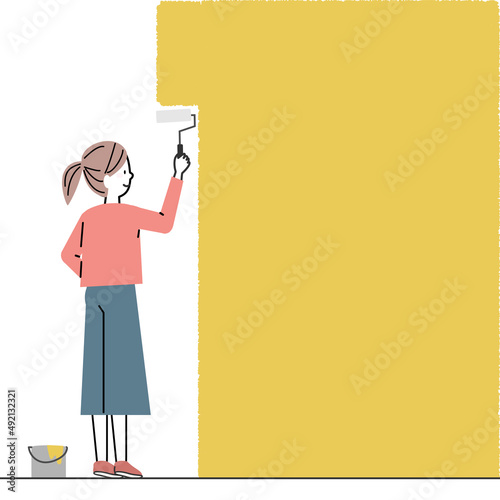 壁にペンキを塗る女性