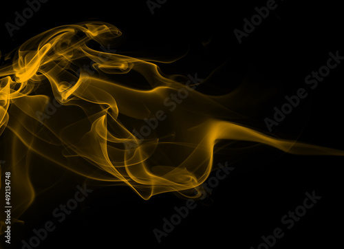 Yellow smoke abstract on black background. drakness concept