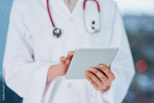 The medical records of every patient in one place. Cropped shot of an unrecognizable female doctor using a tablet while standing in the hospital.