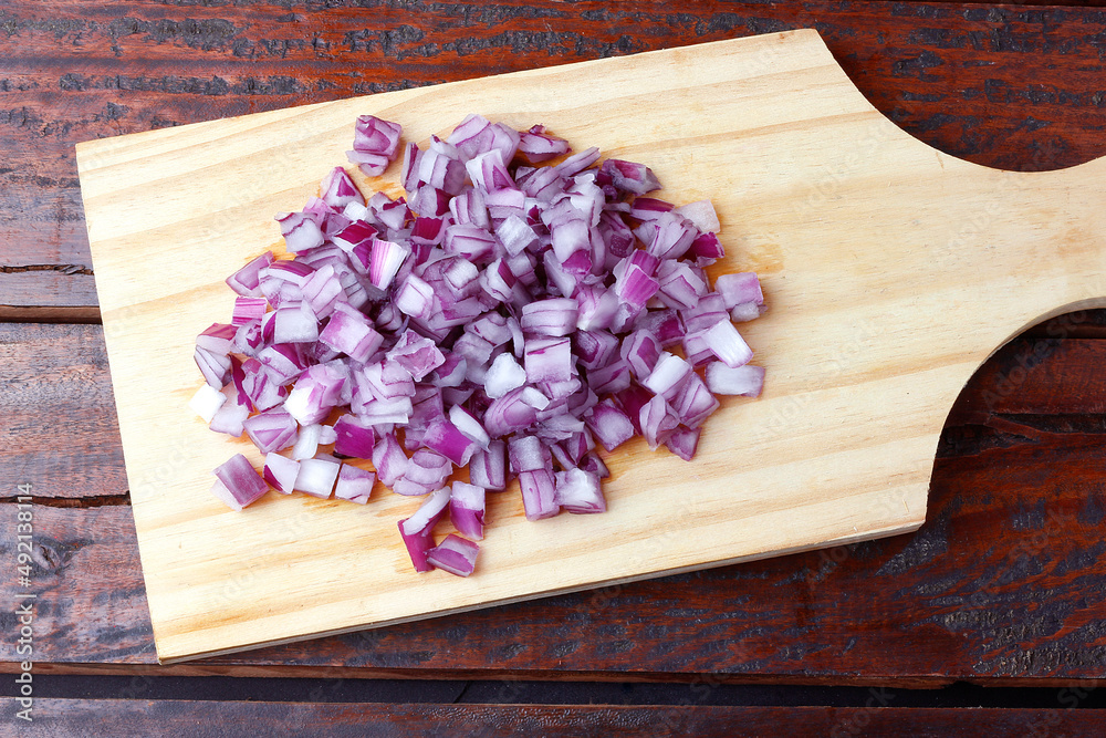 portion of chopped raw red onions over rustic wooden table