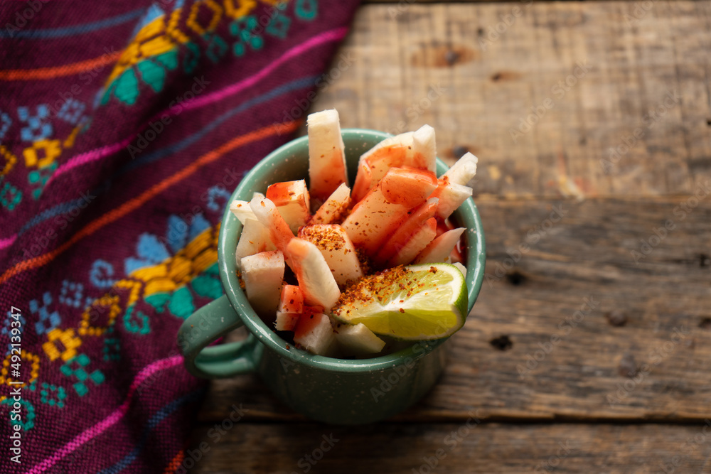 Foto de Mexican yam bean also called Jicama with chili powder and