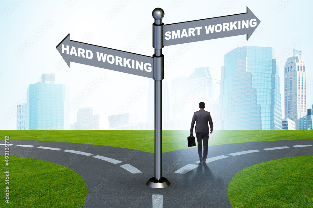 Businessman at the crossroads on working smart or hard Businessman at the crossroads on working smart or hard