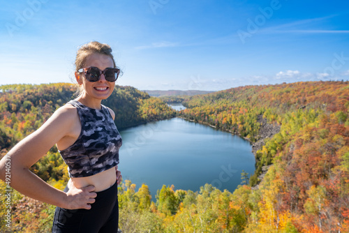Active fit woman wearing athleisure clothing poses at the top of Bean and Bear Lake along the Superior Hiking Trail in fall