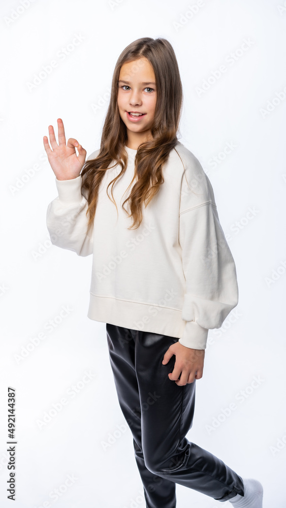 portrait of a girl in the studio. beautiful little girl in a white sweatshirt and trousers is smiling. isolated white background portrait of a girl in the studio. beautiful little girl in a white sweatshirt and trousers is smiling. isolated white background