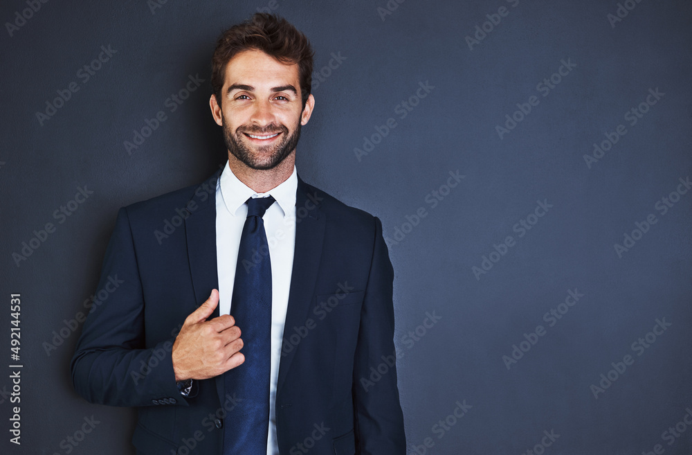 Make success a habit. Studio portrait of a handsome young businessman standing against a grey background. Make success a habit. Studio portrait of a handsome young businessman standing against a grey background.