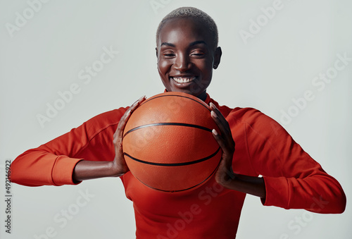 Keen for a couple of hoops. Studio shot of an attractive young woman playing basketball against a grey background. © Nicholas Felix/peopleimages.com