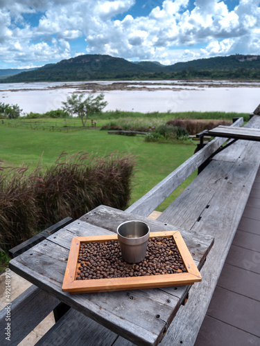 Aluminum Mug Located on Wooden Frame with Coffee Beans photo