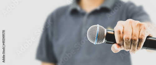 Microphone public speaking background, Close up hand holding microphone for speaker speech presentation stage performance and declaration publication or interview. photo