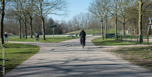 Unrecognizable people cycling and enjoying their day in the park called Haarlemmermeerse bos in Hoofddorp The Netherlands photo