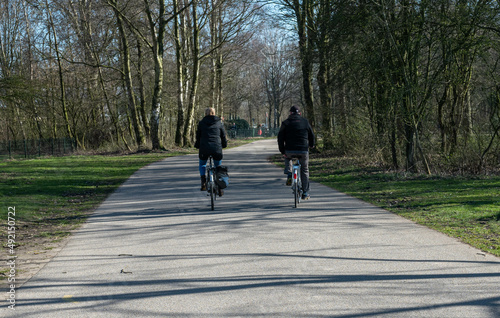 Unrecognizable people cycling and enjoying their day in the park called Haarlemmermeerse bos in Hoofddorp The Netherlands photo