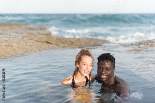 young black man and white woman bathing in the sea