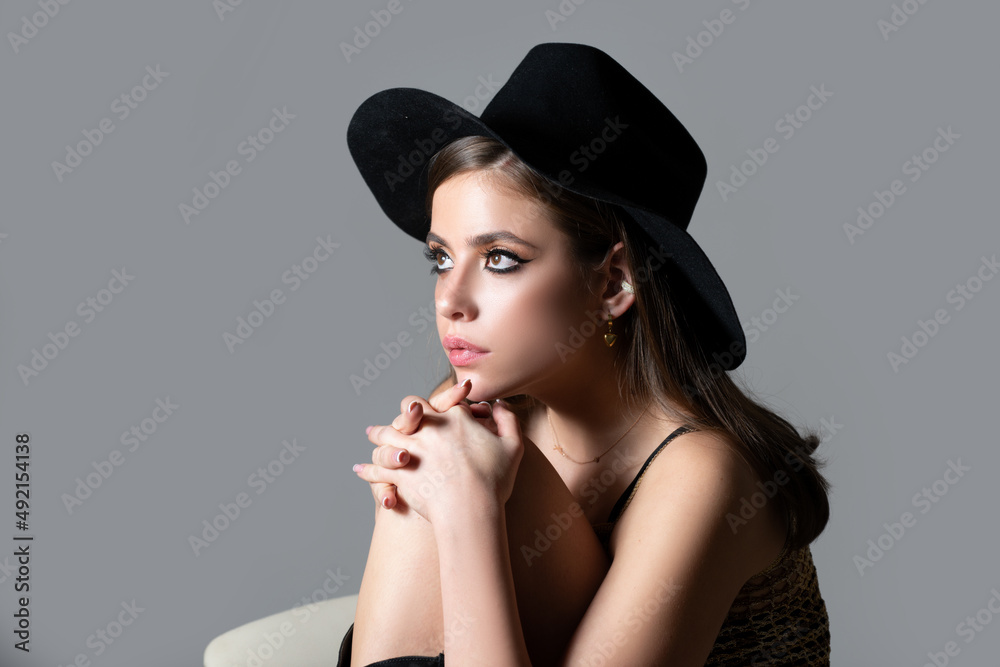 Sensual fashion woman face close up. Beauty portrait of young sexy woman in black hat. Vogue Style Portrait. Sensual fashion woman face close up. Beauty portrait of young sexy woman in black hat. Vogue Style Portrait.