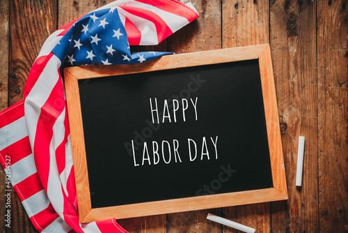 Labor day composition. Blackboard and American flag on a wooden floor.