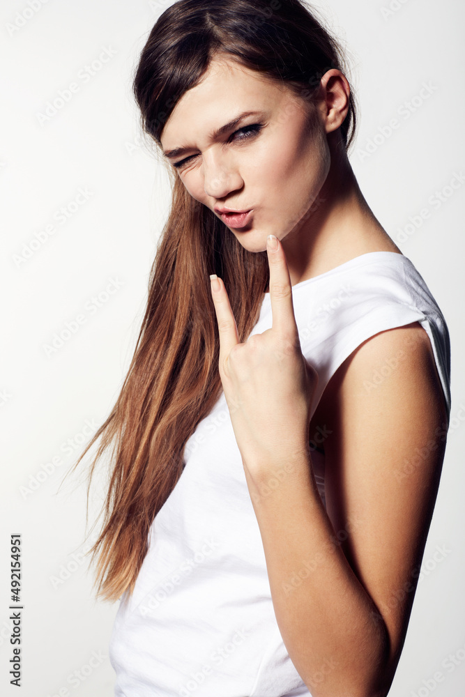 Fototapeta premium Rock on. A funky young beauty giving you devil horns and pouting with attitude.