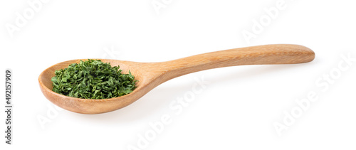 Dried parsley in wood spoon isolated on a white