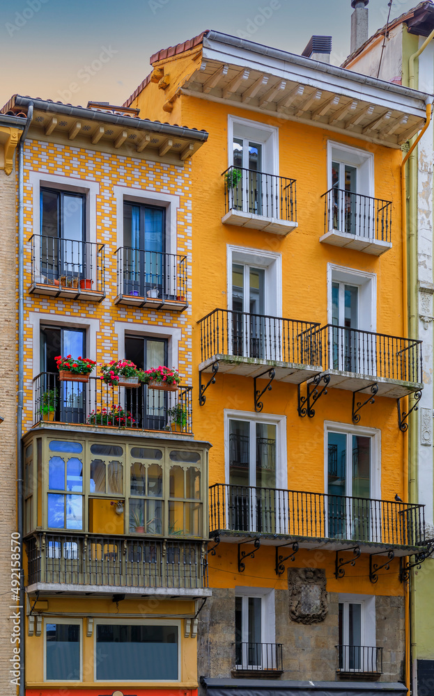 Colorful house facades and ornate metal balconies with flowers in the old town or Casco Viejo in Pamplona, Spain famous for running of the bulls