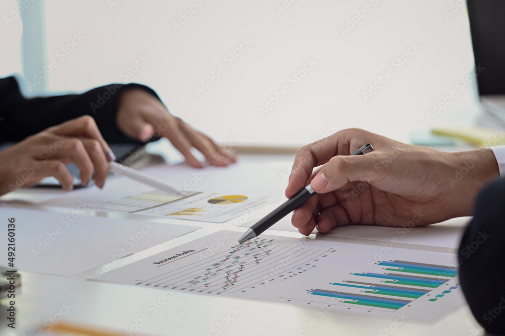 Close up view group of financial advisor analyzing graph together at office desk. Close up view group of financial advisor analyzing graph together at office desk.