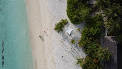 drone shot Beautiful Wedding event decoration beach sea tropical island maldives. Set up arch decor flowers pattern coconut palm trees sand sunlight. Setting outdoor marriage detail table stage 