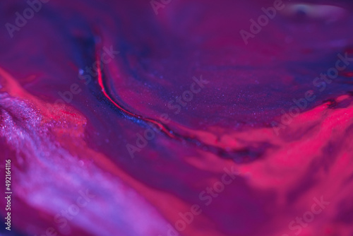 Liquid paint art. Macro ink background. Purple pink colors mix