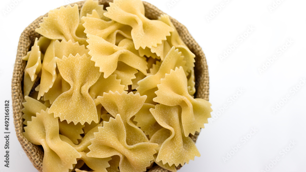 Pasta from durum wheat in a canvas bag on a white background. Close-up. Italian pasta. Pasta from durum wheat in a canvas bag on a white background. Close-up. Italian pasta.