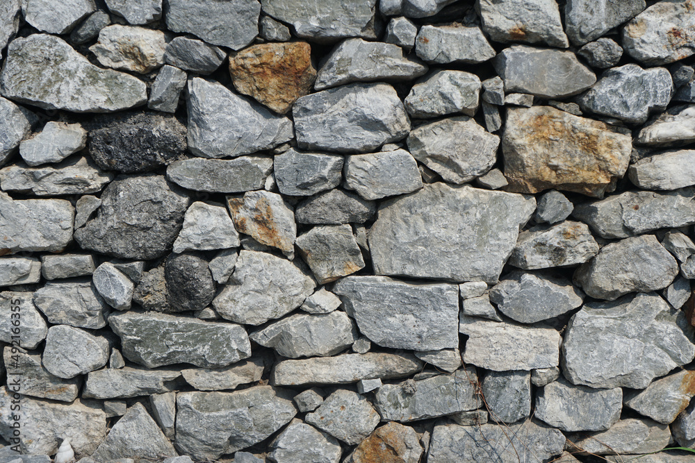 The limestone wall is constructed by a gray wall for background or texture. The limestone wall is constructed by a gray wall for background or texture.