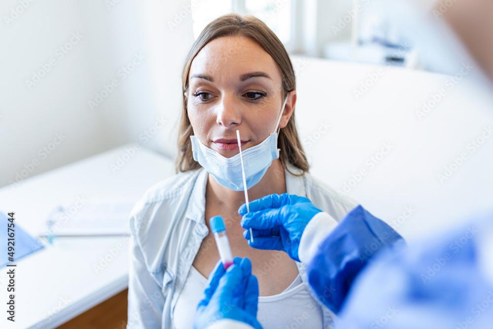 Doctor/nurse taking PCR nasal swab test from a pregnant woman. COVID-19 vaccination concept. Doctor/nurse taking PCR nasal swab test from a pregnant woman. COVID-19 vaccination concept.