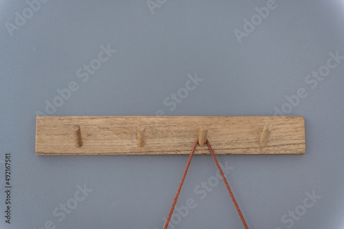 background from a wooden hanger on a gray-blue background and one of the hooks is busy. Composition with rhythm disturbance.