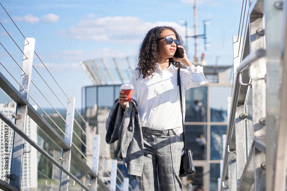 business woman with a takeaway coffee talking on a smartphone . business woman with a takeaway coffee talking on a smartphone .
