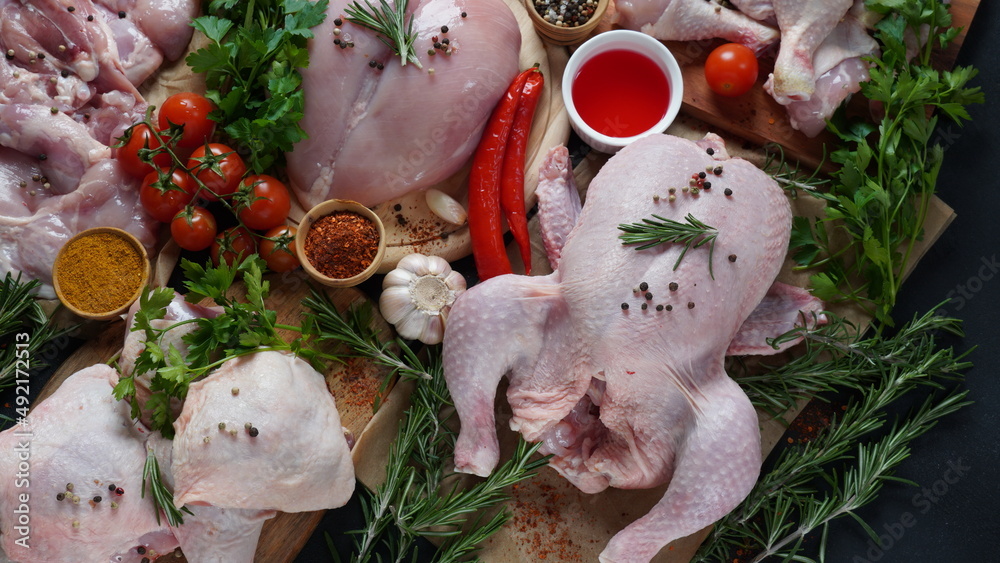 Different types of fresh chicken meat. Whole raw chicken, fillet, thigh, boneless breast, and legs with spices for barbecue grill.