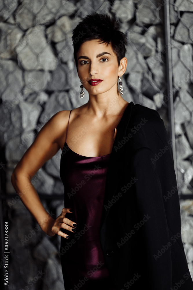 Fototapeta premium Portrait of serious elegant female leader look at the camera, wearing stylish dress. Beautiful elegant business woman posing with cross hands, attractive gorgeous lady boss show confidence and success