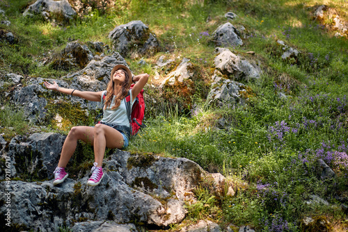 Fototapeta Caucasian woman sitting on rock in forest