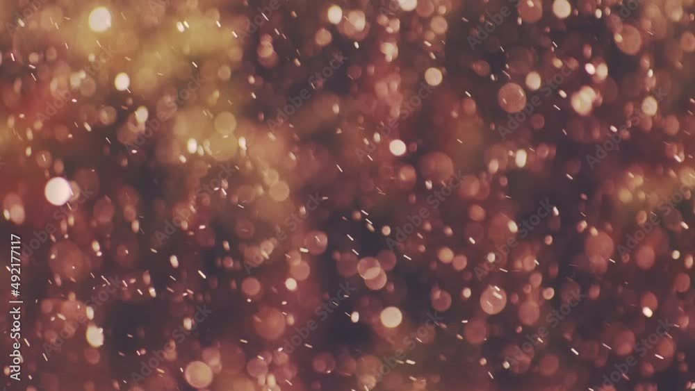 The falling snow outside the window is blurred and an amazing abstraction is obtained from small shiny circles. On a colored blurred background that move like falling snow.