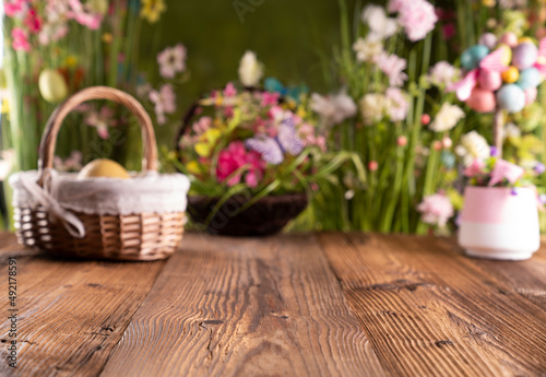 Easter time. Easter decorations on the rustic wooden table. Easter bunny  easter eggs in basket. Bouquets of spring flowers. 