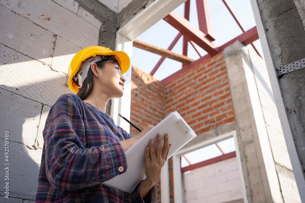 Female Asian,Beautiful Engineer,Architecture Smile and holding a clipboard for house inspection.Portrait of Professional Heavy Industry Female wearing a hardhat.Evolution construction concept.banner. Female Asian,Beautiful Engineer,Architecture Smile and holding a clipboard for house inspection.Portrait of Professional Heavy Industry Female wearing a hardhat.Evolution construction concept.banner.