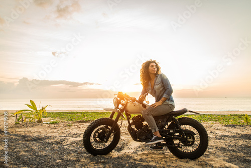 Female biker driving a cafe' racer motorbike photo