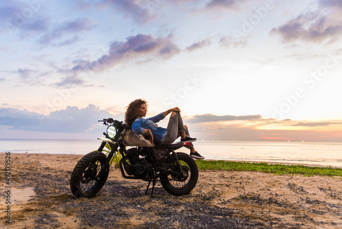 Female biker driving a cafe' racer motorbike