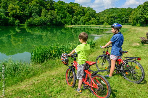 Zwei Teenager genießen eine kurze Pause am See bei einer Radtour
