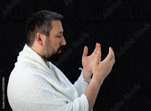 Muslim pilgrims in white traditional clothes, praying at Kaaba in Makkah. High quality photo photo