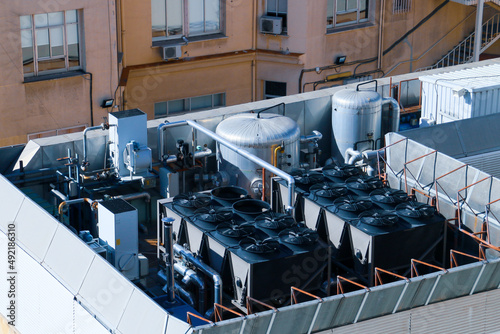 Maquinaria de aire acondicionado industrial en la azotea de un edificio en Madrid, España. Complejo sistema de maquinaria y tuberías con el que está equipado un edificio moderno. photo