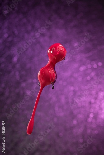 Transparent lubricant drips down over red kegel balls Geisha balls on a purple background. Vaginal balls for a woman. Sex toys Copy spaceVaginal simulator for girls Women's Intimate Health Trainer