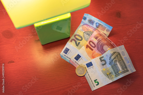 Euro bills and currency on a table with a lighted lamp