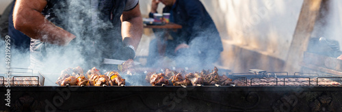 Fotografia Roasting meat on the grill. Cooking fast food on the street.