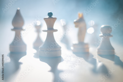 Silhouettes of chess pieces in the smoke of war. Blue haze and smoke or fog. Abstraction of the battle strategy. Business.