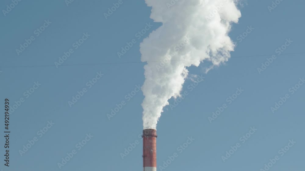 Smoke, emissions from industrial chimney against blue sky background. Copy space Smoke, emissions from industrial chimney against blue sky background. Copy space